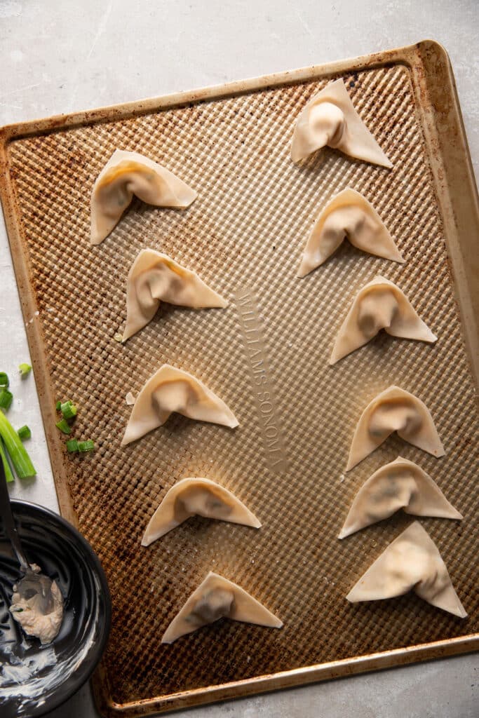 cream cheese wontons prior to baking on a baking sheet