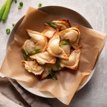 cream cheese wontons in a bowl with green onions on top