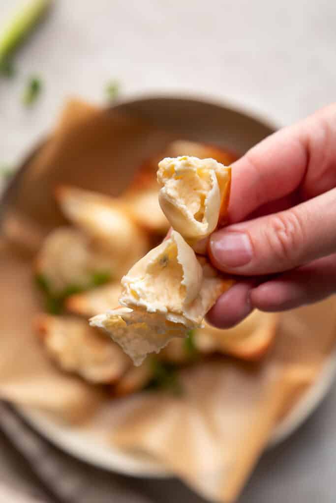 cream cheese wontons in a bowl with green onions on top