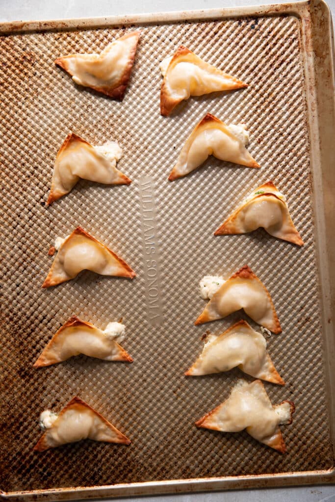 cream cheese wontons after baking on a baking sheet