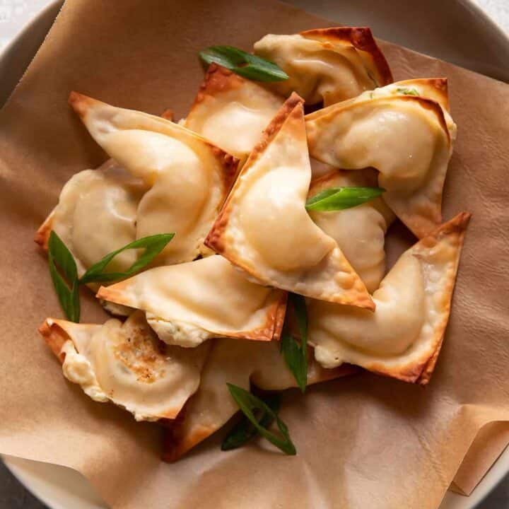 cream cheese wontons in a bowl with green onions on top