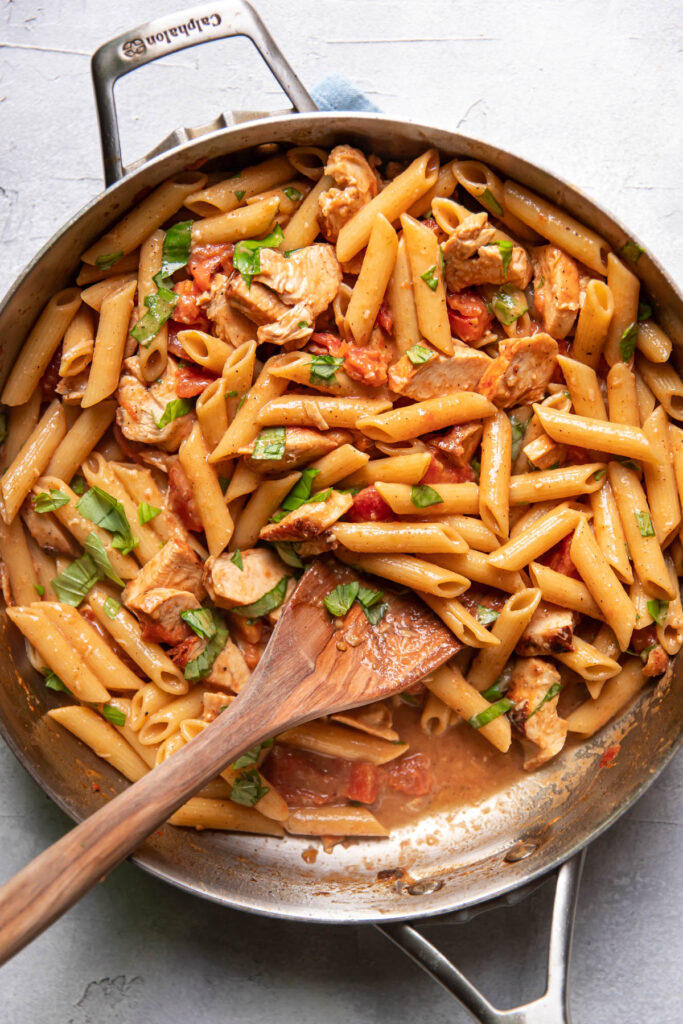 Lemon basil chicken pasta in a saute pan.
