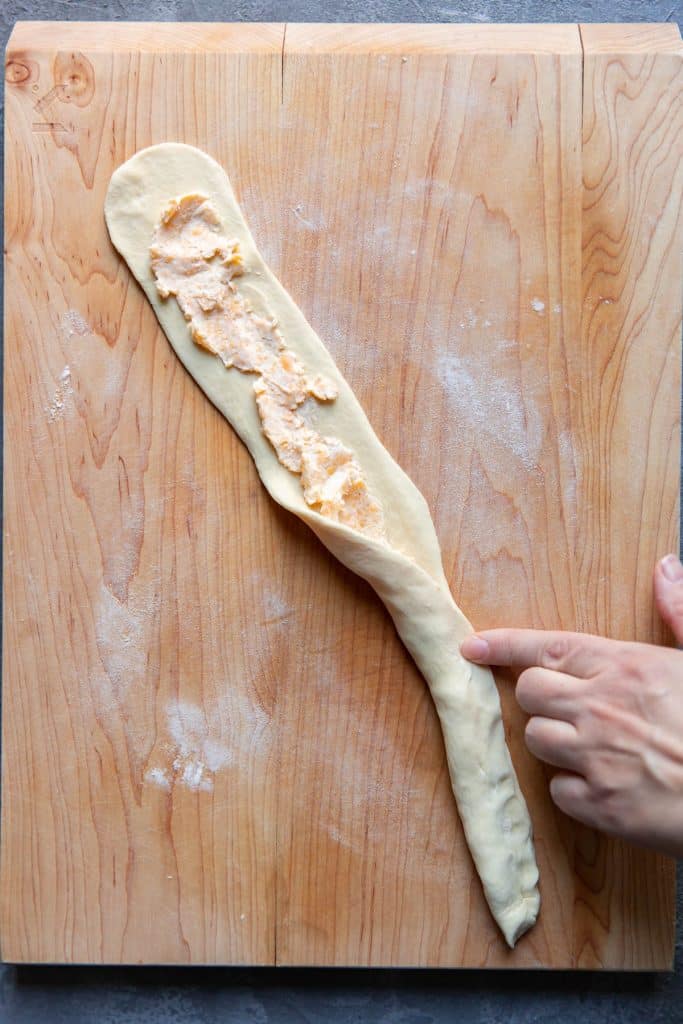 pretzel dough stretched with cheese on it