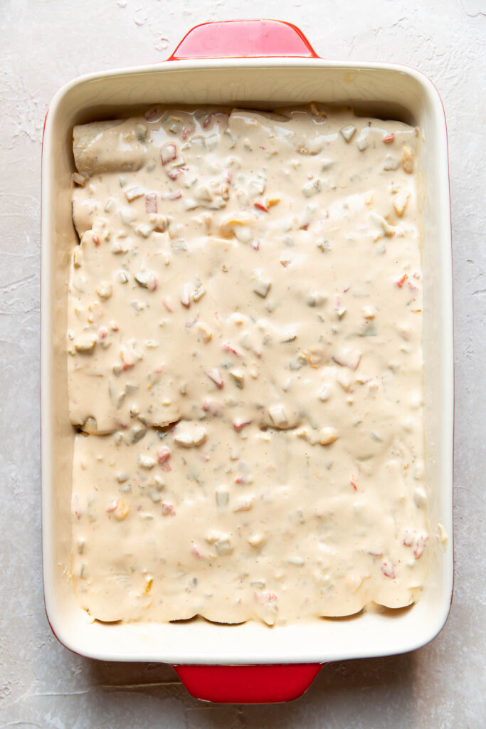 Enchiladas in a baking dish before being baked.