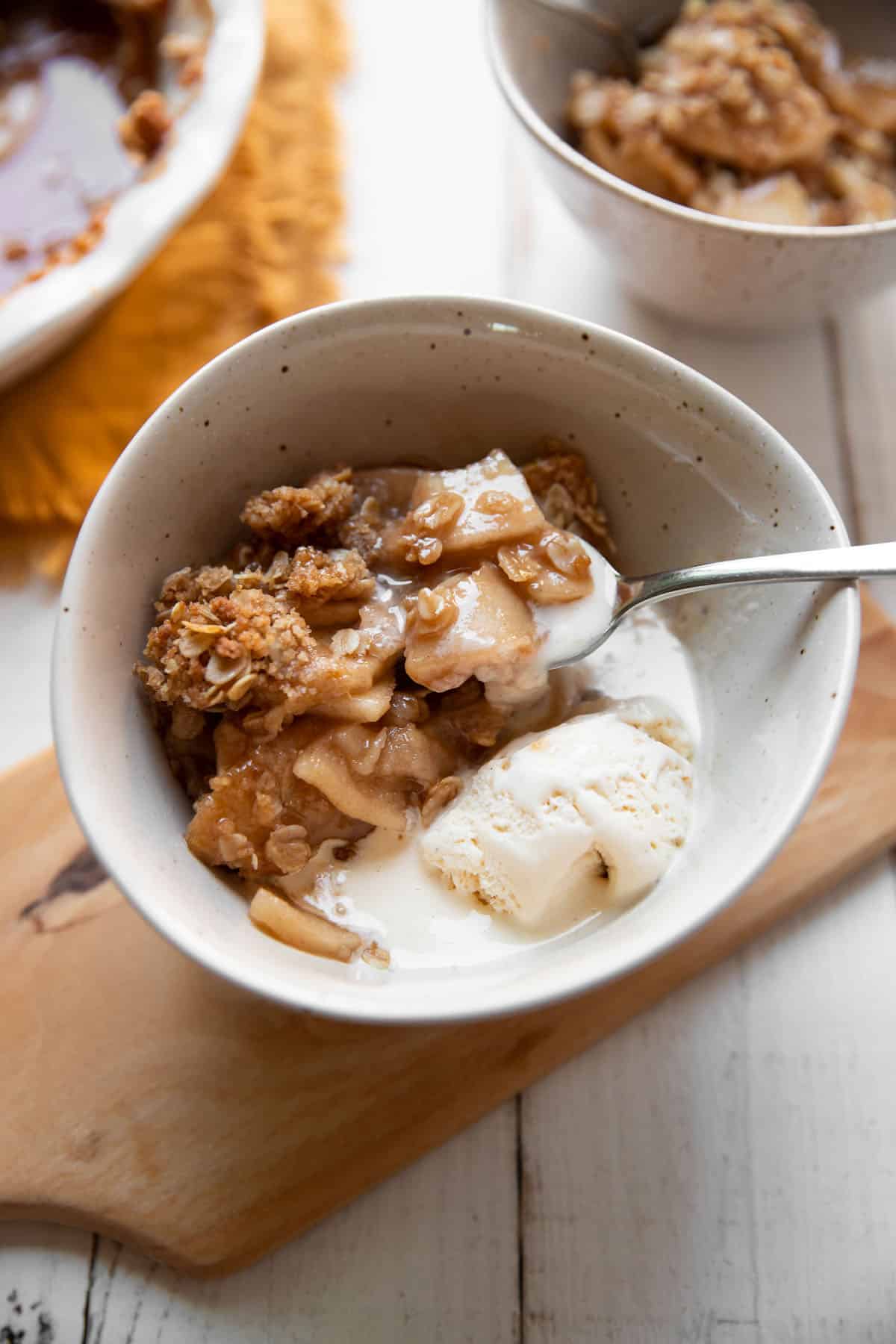 bowl of apple crisp and vanilla ice cream