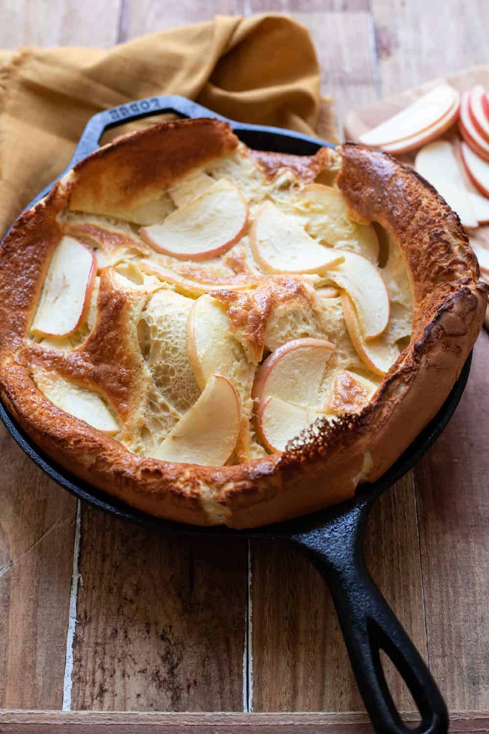 Beautiful, puffy cinnamon apple dutch baby.  Crispy buttery edges and  dreamy honey crisp apples make this cinnamon apple dutch baby pure perfection.  A dust of cinnamon sugar completes it.