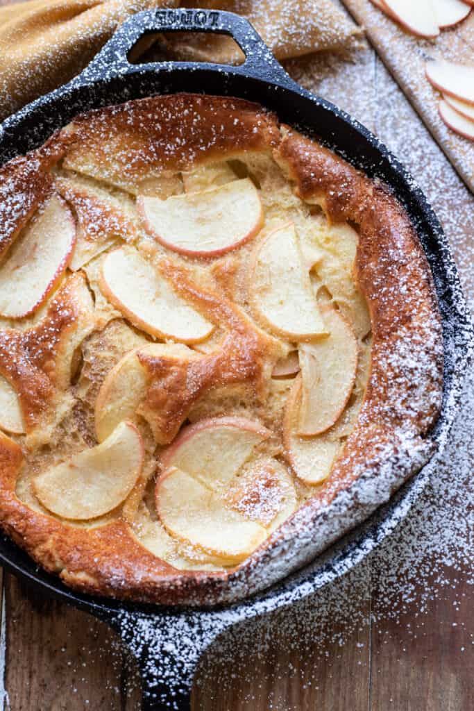 Beautiful, puffy cinnamon apple dutch baby. Crispy buttery edges and dreamy honey crisp apples make this cinnamon apple dutch baby pure perfection. A dust of cinnamon sugar completes it.