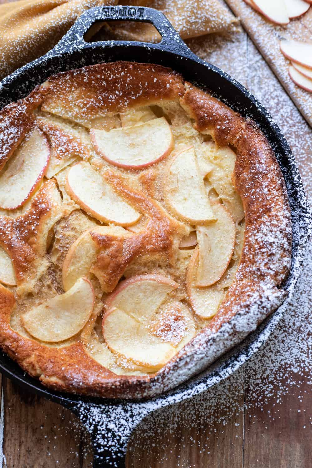 Beautiful, puffy cinnamon apple dutch baby.  Crispy buttery edges and  dreamy honey crisp apples make this cinnamon apple dutch baby pure perfection.  A dust of cinnamon sugar completes it.