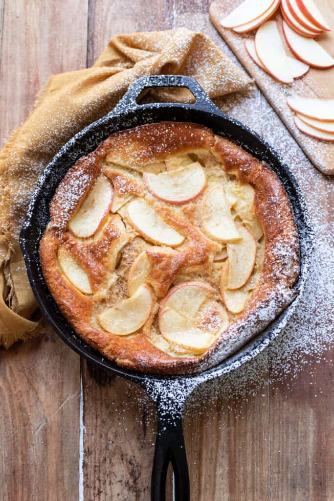 Beautiful, puffy cinnamon apple dutch baby. Crispy buttery edges and dreamy honey crisp apples make this cinnamon apple dutch baby pure perfection. A dust of cinnamon sugar completes it.