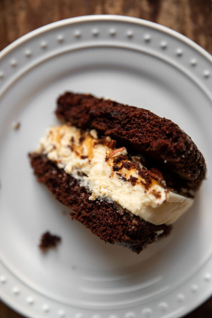 Cheesecake layered between chocolate cake and salted caramel with pecans