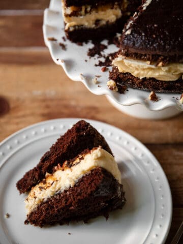 Cheesecake layered between chocolate cake and salted caramel with pecans