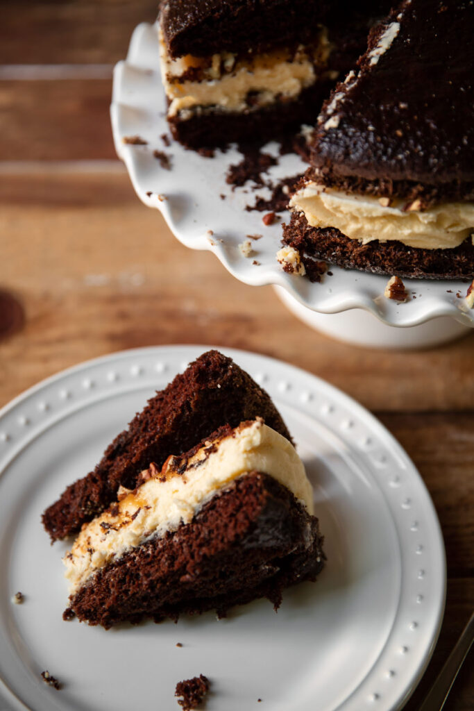 Cheesecake layered between chocolate cake and salted caramel with pecans