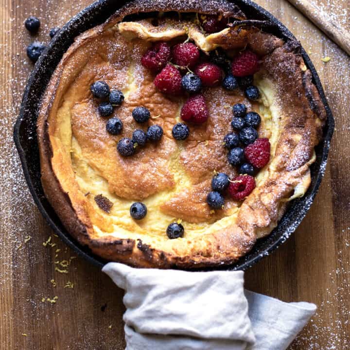 skillet dutch baby with lemon zest blueberries and raspberries