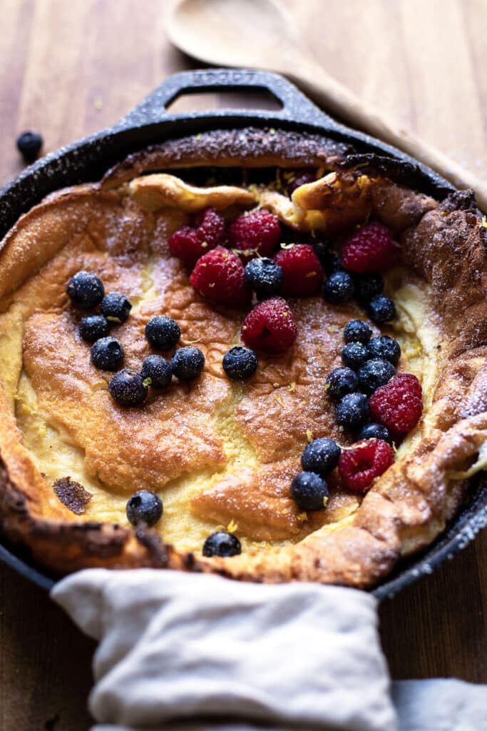 skillet dutch baby with lemon zest blueberries and raspberries