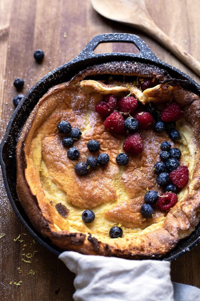 skillet dutch baby with lemon zest blueberries and raspberries