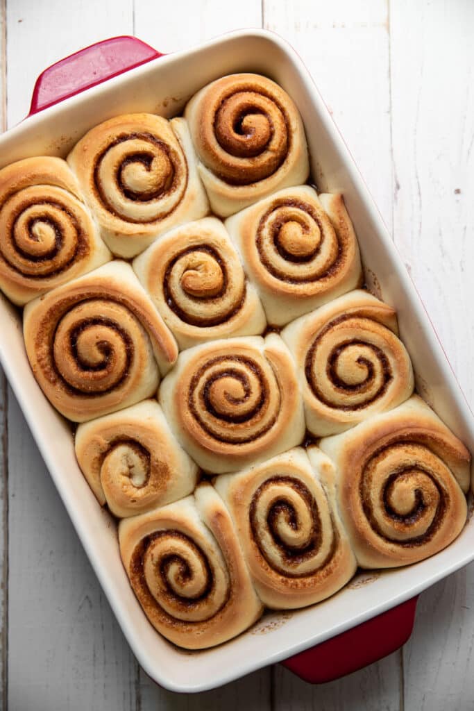 cooked cinnamon rolls in a baking pan