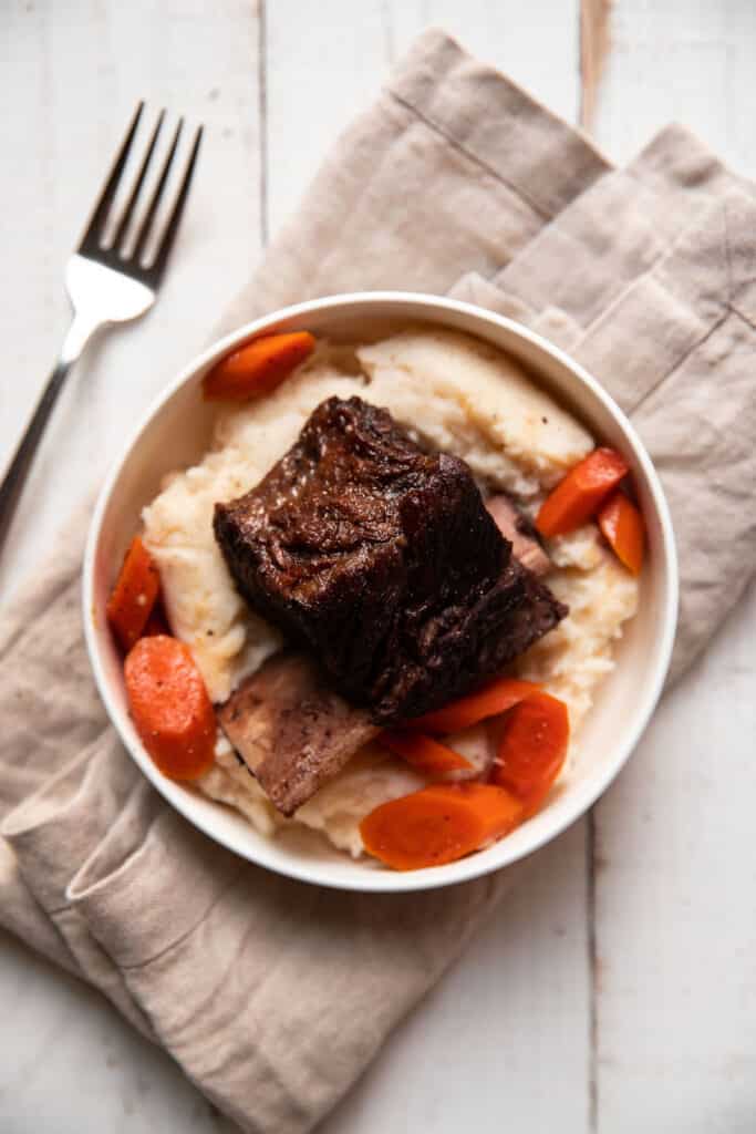 tender short ribs braised in red wine with gouda mashed potatoes and cooked carrots