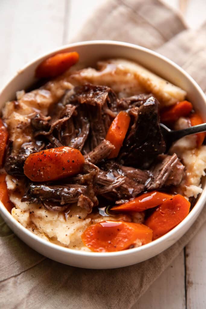 tender short ribs braised in red wine with gouda mashed potatoes and cooked carrots