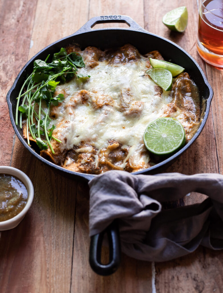 corn tortilla short rib enchiladas in a skillet