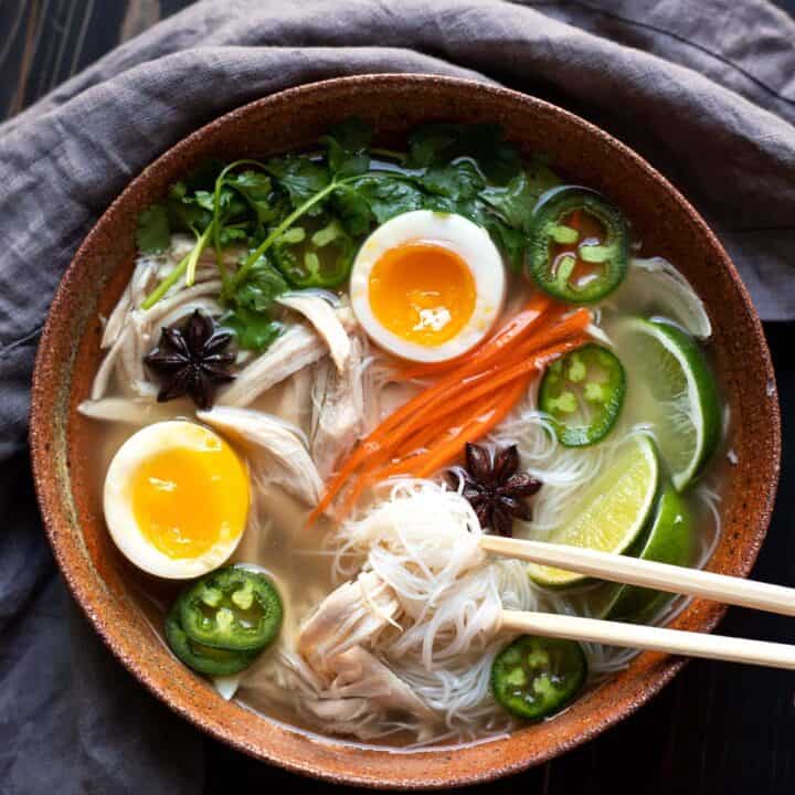 bowl of chicken pho with soft boiled egg jalapeno cilantro rice noodles