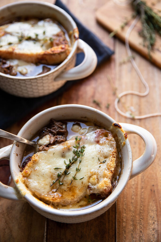 bowl of pot roast and french onion soup with swiss cheese melted over bread