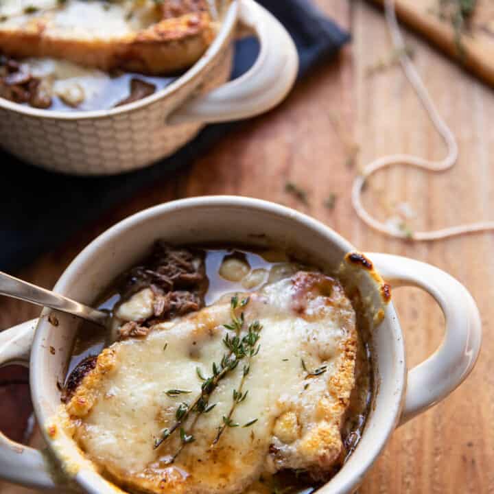 bowl of pot roast and french onion soup with swiss cheese melted over bread