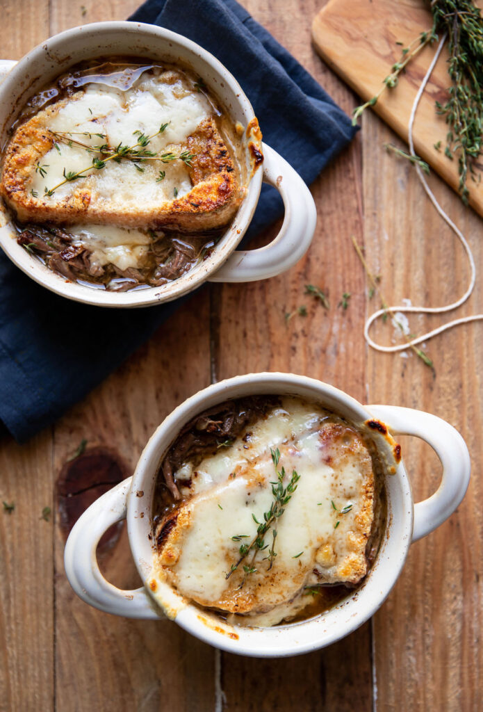bowl of pot roast and french onion soup with swiss cheese melted over bread
