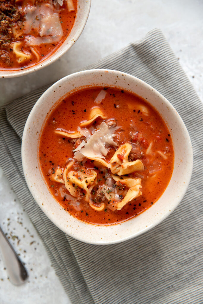 tomato soup with cheese tortellinis and ground beef in a bowl