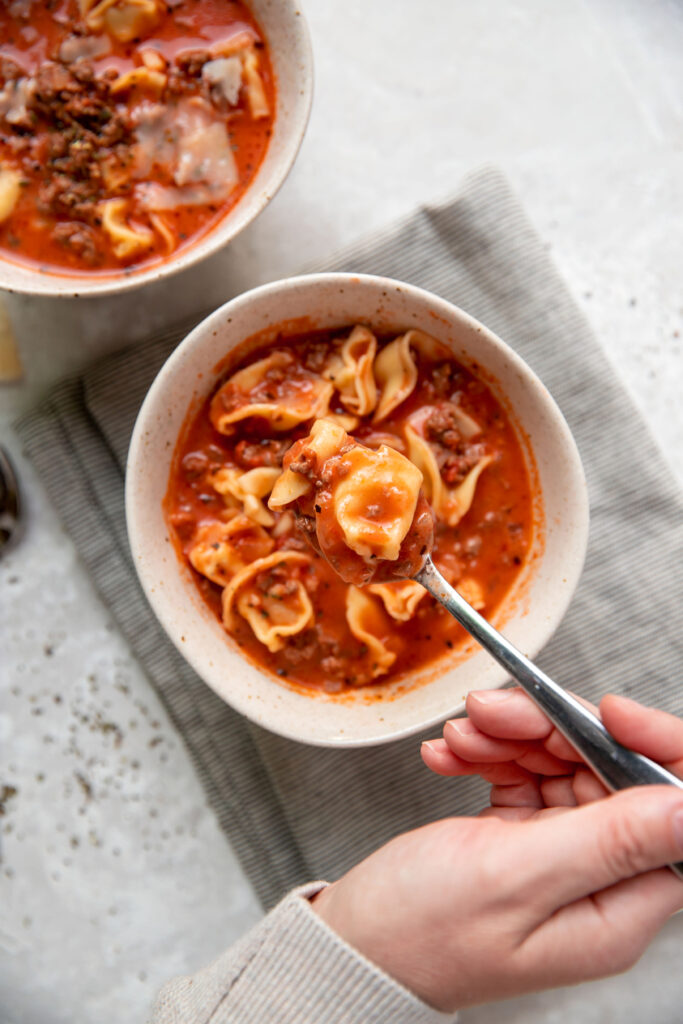tomato soup with cheese tortellinis and ground beef in a bowl