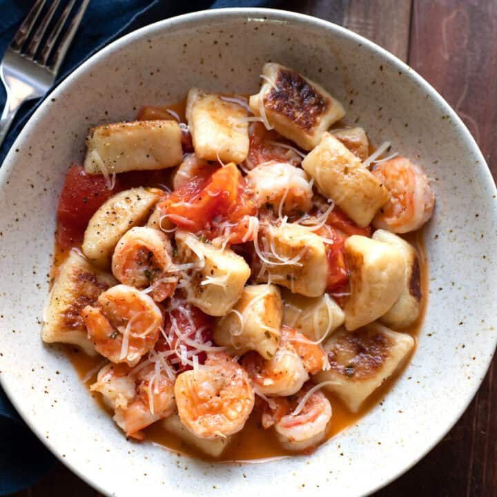 gnocchi with tomatoes and a white wine sauce in a bowl