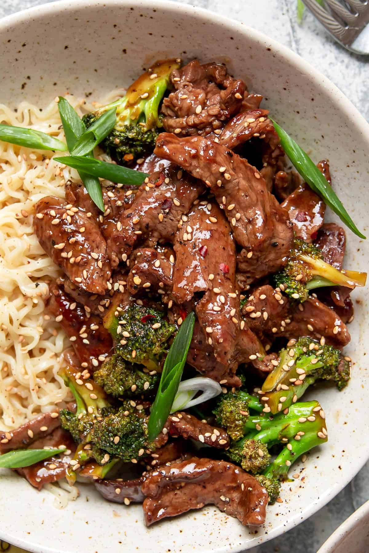 beef and broccoli with ramen noodles in a bowl.