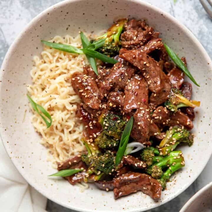 beef and broccoli with ramen noodles in a bowl.