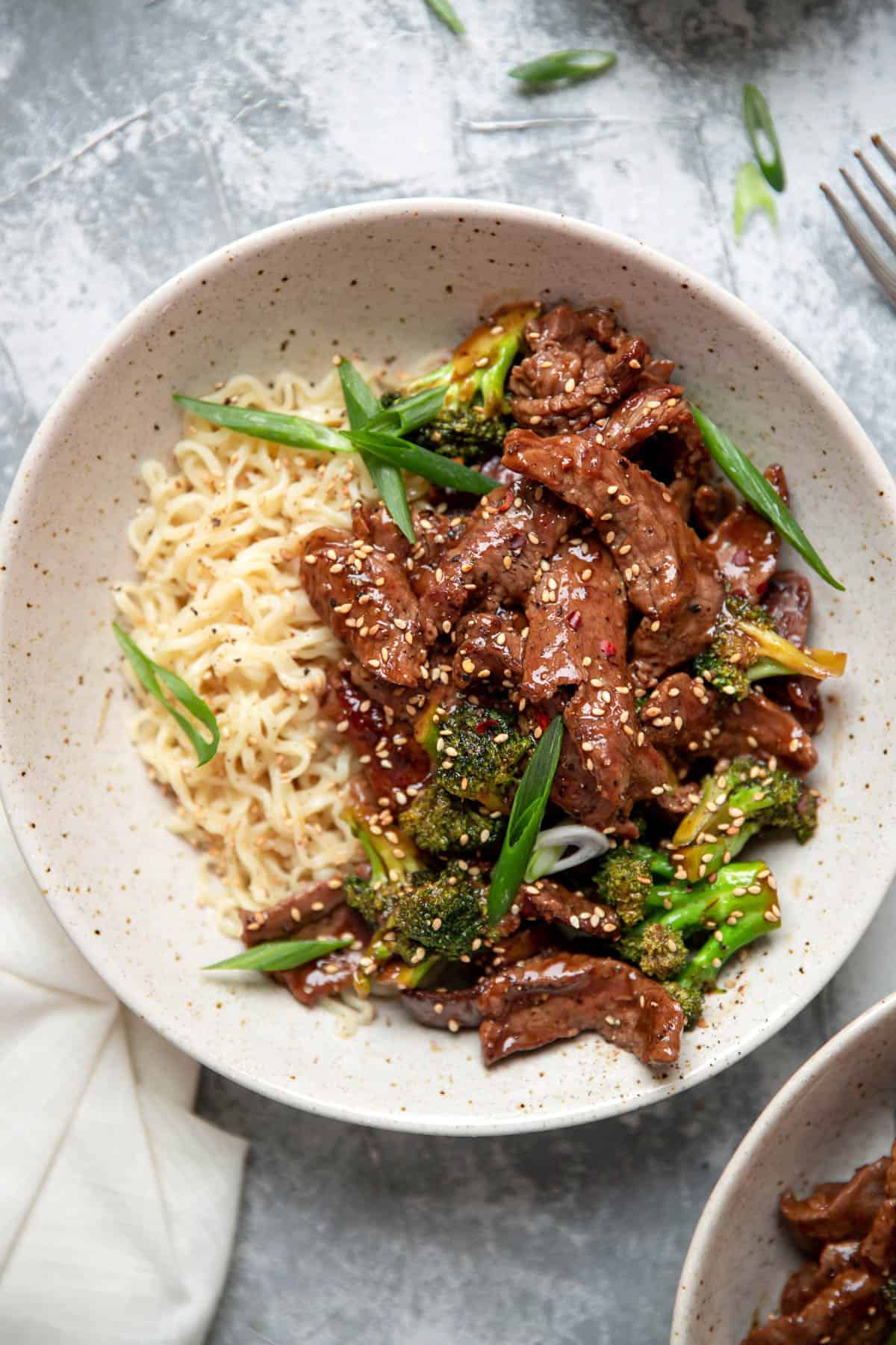 beef and broccoli with ramen noodles in a bowl.