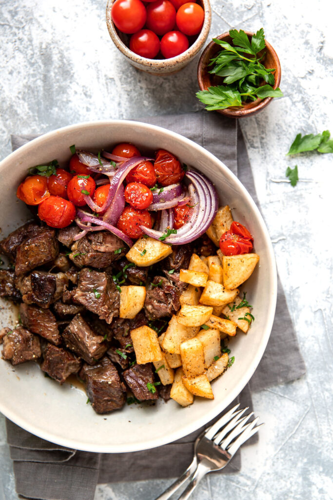 slow cooker steak bites with butter lemon sauce tomato and crispy potatoes