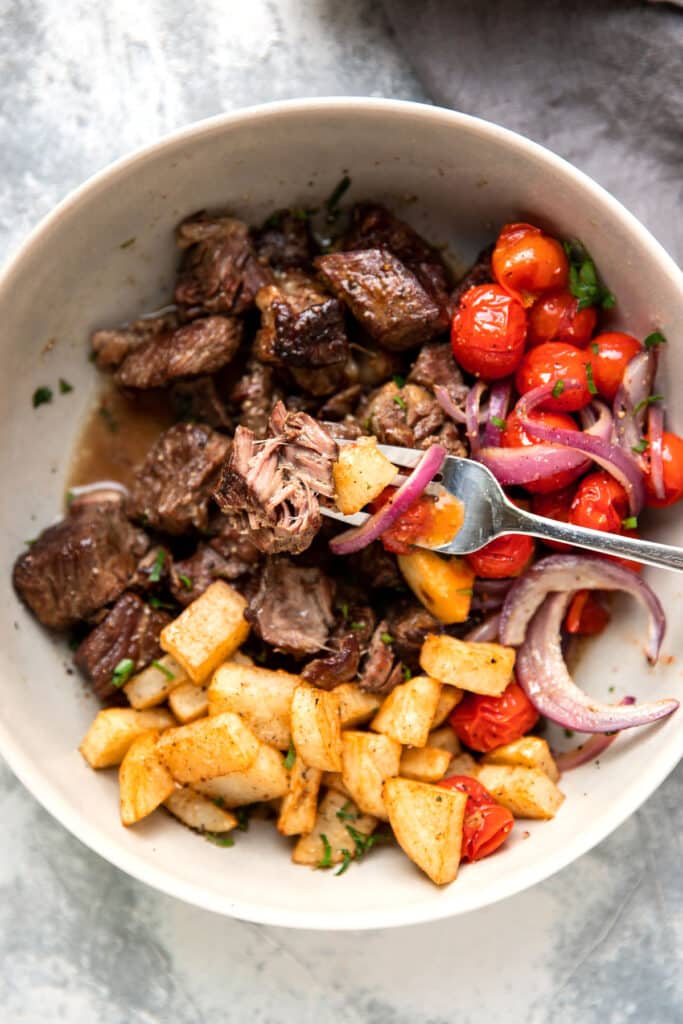 slow cooker steak bites with butter lemon sauce tomato and crispy potatoes