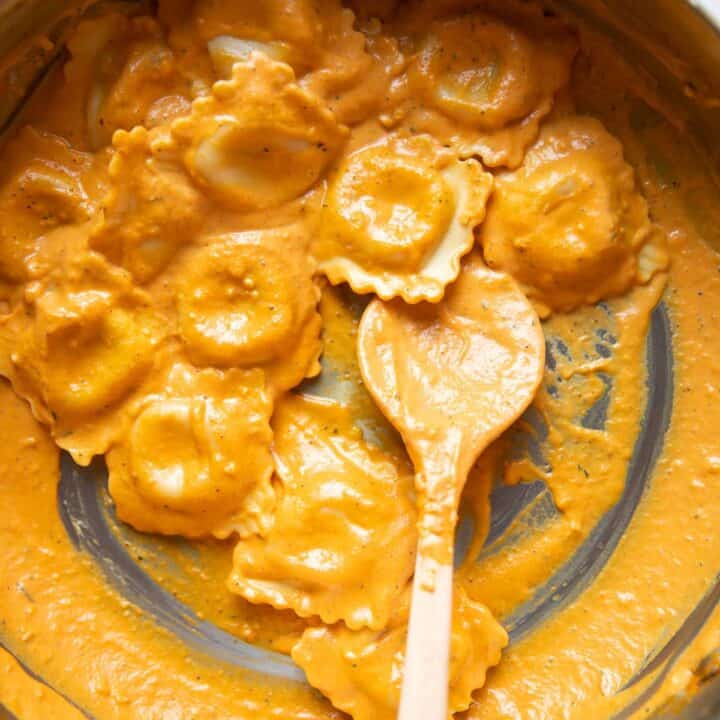pumpkin ravioli with rosemary and cream sauce in a pan.