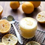 lemon curd in a jar with lemon slices around it