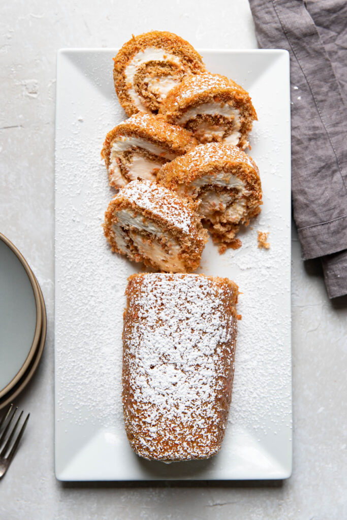 Carrot cake in a roll cake form with cream cheese frosting.