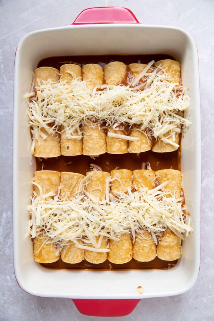 enchiladas with cheese on top in a baking pan before cooking