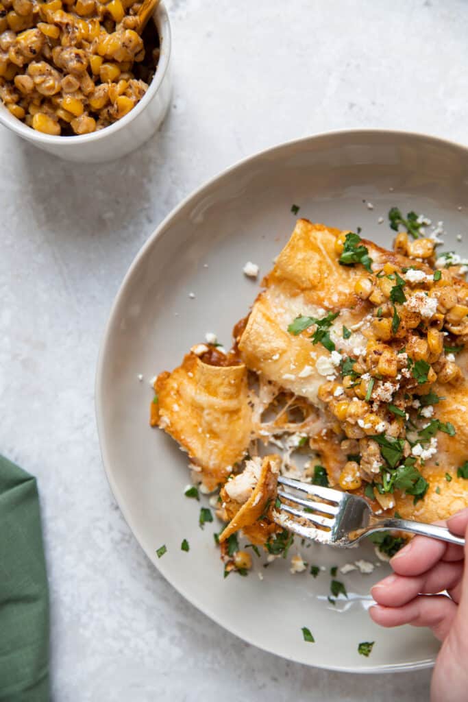 plate of chicken enchiladas with cilantro cotija cheese and elote corn