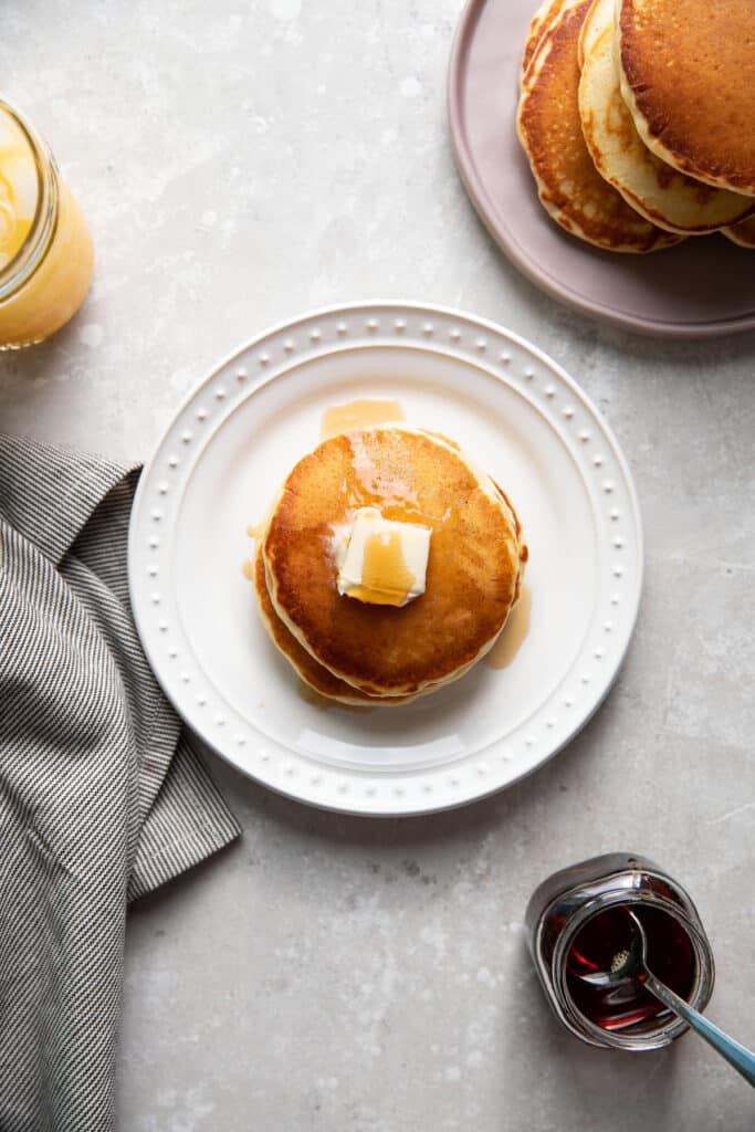 buttermilk pancakes on a plate with butter and maple syrup on top