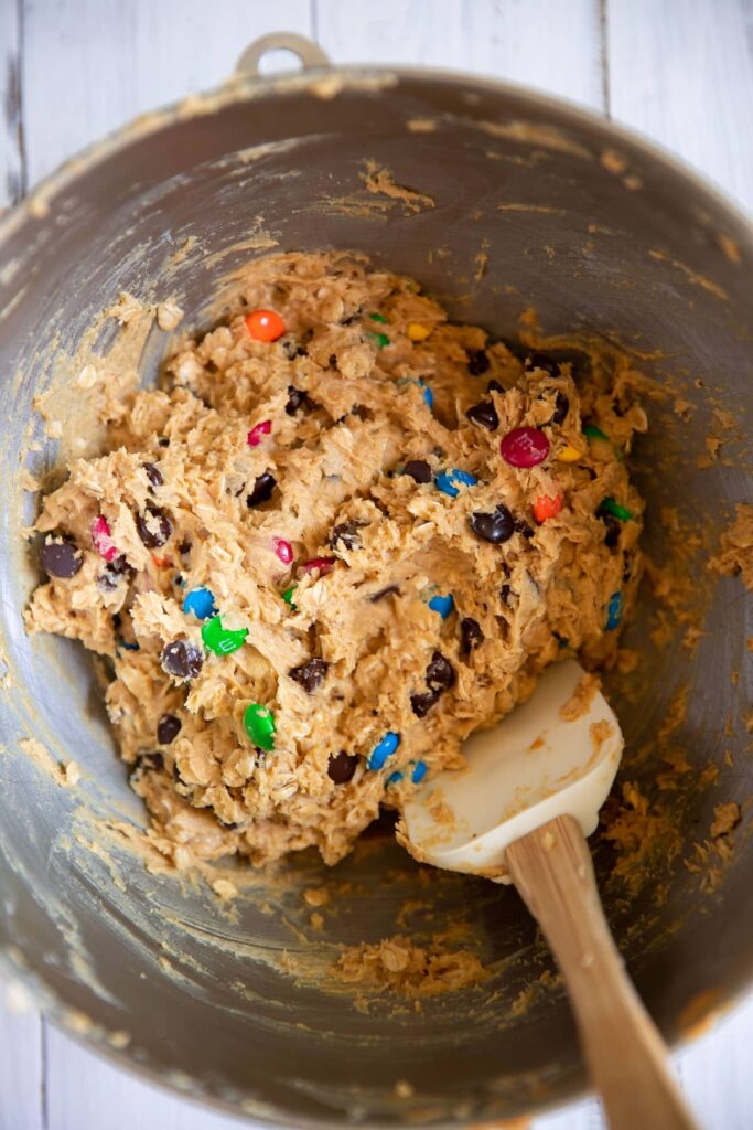 monster cookie raw dough batter in a mixing bowl with a spatula