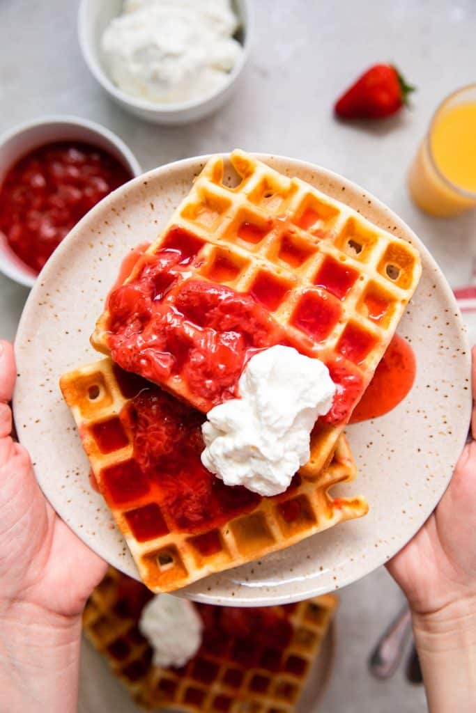 waffles with strawberries and whipped cream on top