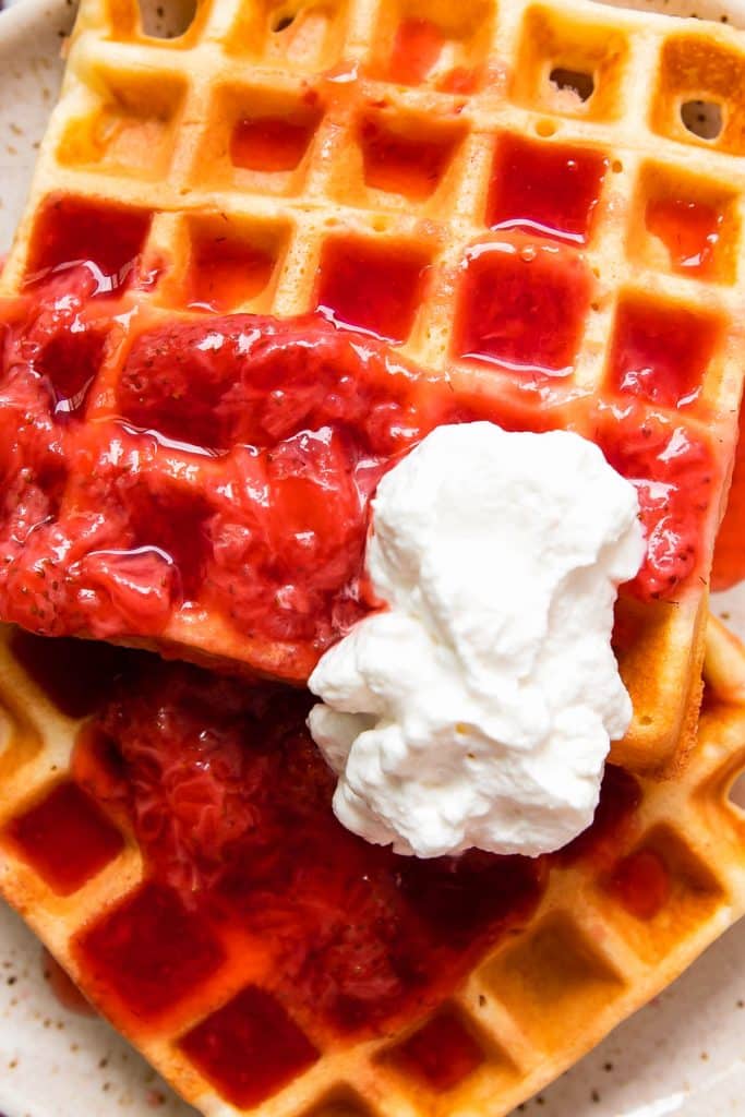 waffles with strawberries and whipped cream on top