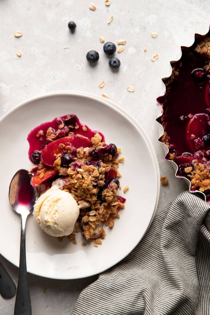 Plate of blueberry peach crisp with vanilla ice cream