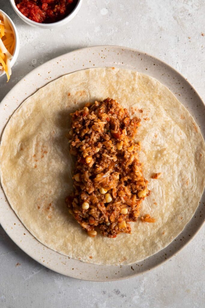 mexican beef and rice on a tortilla on a plate