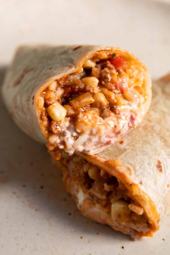 mexican beef and rice rolled up in to a burrito with sour cream inside