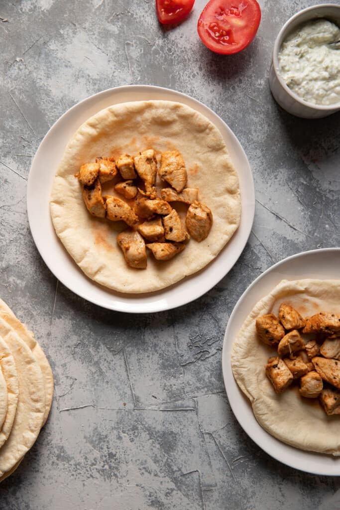 plates with pitas and mediterranean chicken