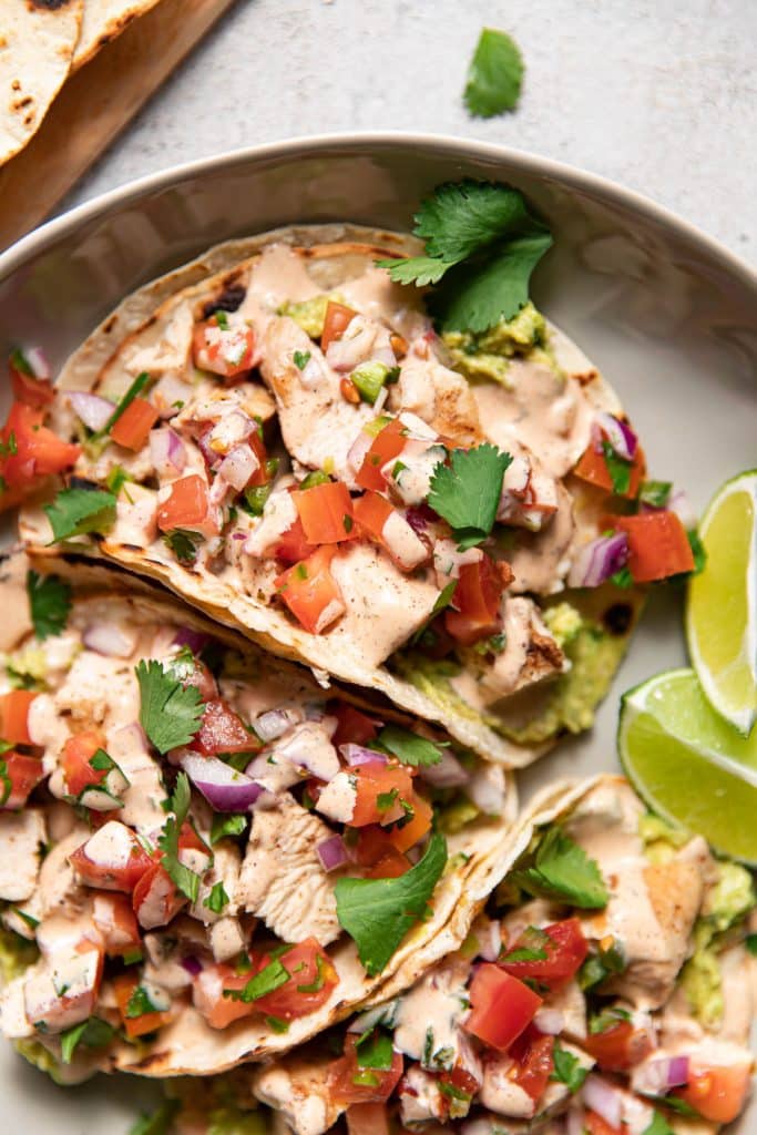 plate of chicken street tacos with aioli and guacamole
