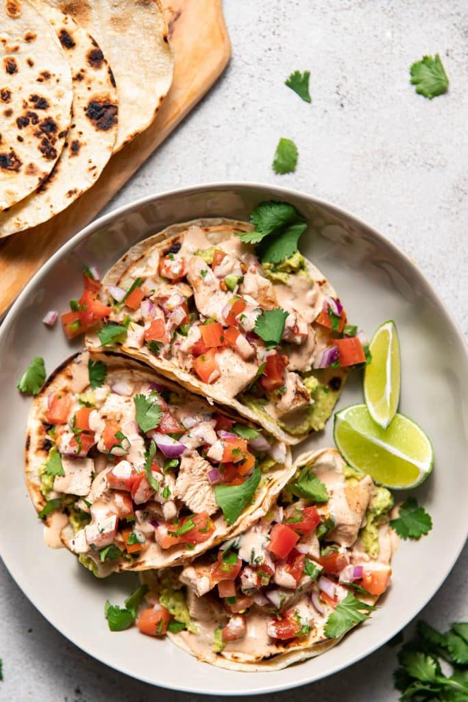 plate of chicken street tacos with aioli and guacamole